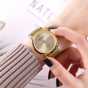 Montre à quartz dorée pour femme avec bracelet en maille et index en strass au poignet