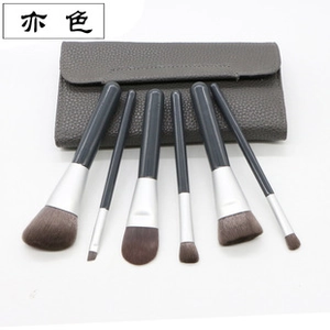 Detailed view of 6-piece portable makeup brush set with dark grey leather storage case