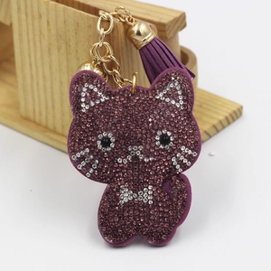 Detail of purple rhinestone cat keychain featuring golden chain and suede tassel ornament