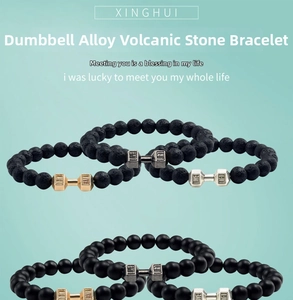 Detailed view of matte beads and lava stone bracelets with engraved dumbbell charms