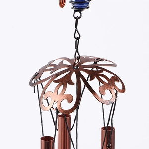 Detail of vintage bronze butterfly wind chime with metal tubes and blue bead decoration