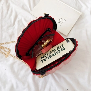 Pink shell chain bag with red lining and interior space for phone and makeup