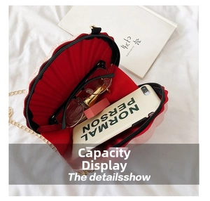 Internal view of a pink shell-shaped crossbody bag with a red lining and gold chain