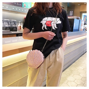 Pink glitter shell crossbody bag with golden metal chain strap worn by a model