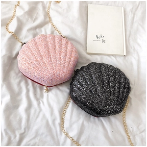 Detail of shell-shaped crossbody bags in pink and black sequins with gold chain