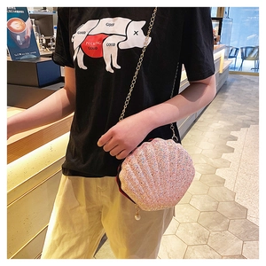 Detailed shot of pink sequin shell bag featuring gold chain and pearl decoration