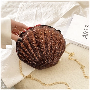 Detail of glitter shell crossbody bag with gold chain strap and velvet lining