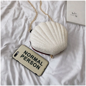 Top view of white glitter shell bag with gold chain strap and pearl decor