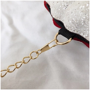 Detail of glitter shell bag featuring golden chain strap and durable black zipper