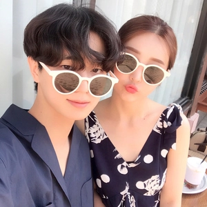 Retro milk tea round sunglasses worn by a couple in a bright indoor setting