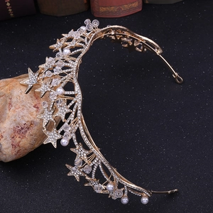 Dettaglio di un diadema da sposa dorato con strass a stella e perle bianche eleganti
