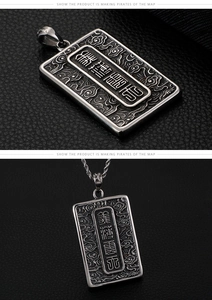 Macro detail of vintage silver rectangular pendant with ornate engravings and rope chain