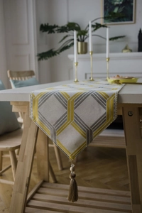 Detailed view of jacquard table runner with geometric patterns and beaded tassel fringe