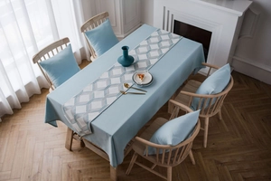 Detail view of light blue jacquard table runner with geometric patterns in home setting