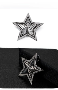 Detailed macro view of a vintage stainless steel star pendant with industrial punk texture