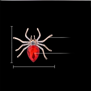 Detailed view of spider brooch dimensions 6cm x 5cm with red crystal and gold finish
