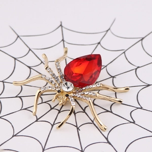 Detail shot of a sparkling spider brooch with red crystal and diamonds on a cobweb background
