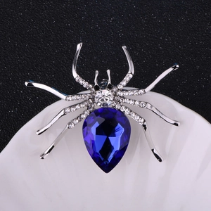 Macro shot of a sparkling spider brooch featuring a large blue pear-shaped gemstone