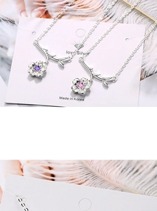 Detail of silver flower and branch necklaces with pink and purple zircon accents
