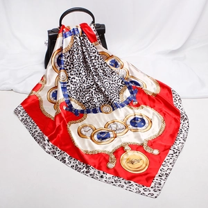 Detailed texture of luxurious satin silk scarf with gold chain and crown pattern