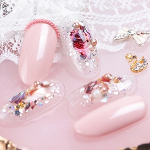 Macro detail of iridescent shell flakes and pearls on decorative false nail art