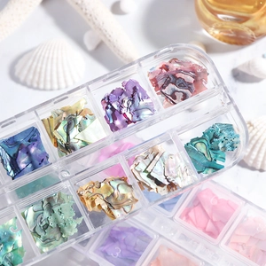 Detailed macro shot of irregular iridescent nail art shell flakes in two storage cases