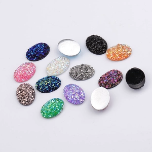 Flat lay of oval resin cabochons with glitter texture for DIY jewelry making accessories