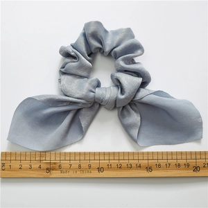 Blue satin bow hair scrunchie with measuring ruler showing 20cm width on white background