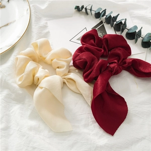 Elegant cream and burgundy satin bow scrunchies with long ribbons on minimalist background