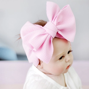 Pink waffle fabric baby headband with a giant bow for photography and party style