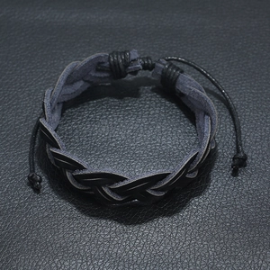 Minimalist black braided leather bracelet with adjustable cord on black background