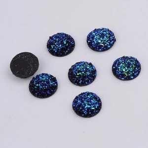 Macro view of 14mm round resin cabochons with sparkling blue and green druzy texture