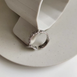 Macro detail of silver irregular hammered texture on 925 sterling silver open ring