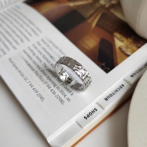 Macro shot of silver 925 irregular ring with unique cracked texture on an art book