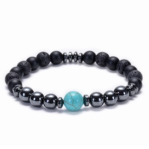 Macro detail of natural lava rock, matte black beads, and turquoise on elastic bracelet