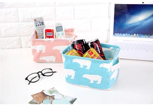 Detail of fabric storage basket with polar bear print and handles on a desk