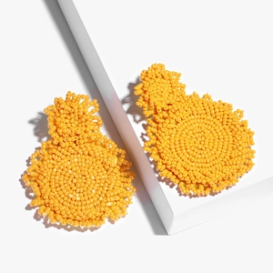 Handmade yellow seed bead double drop earrings on white geometric minimalist background
