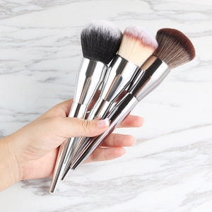 Detailed shot of three metallic silver makeup brushes with varied bristle colors