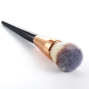 Large fluffy powder brush with soft gradient bristles and rose gold ferrule on white