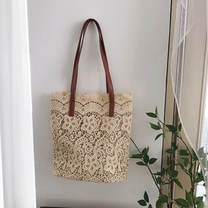 Detail of cream lace tote bag with floral embroidery and brown PU leather handles