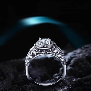 Luxe halo verlovingsring met ronde steen en baguette diamanten op donkere rotsachtergrond