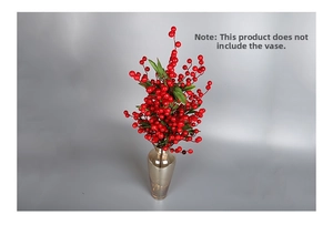 Detail of red artificial berry stems with green leaves in a glass vase for Christmas decor