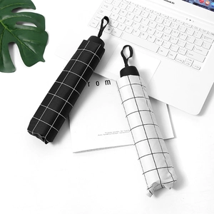 Minimalist striped folding umbrella with black and white grid patterns in a modern setting