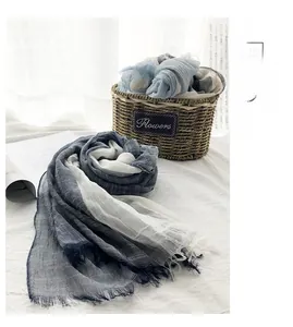 Detail of blue and white gradient cotton linen scarf with frayed fringe edges