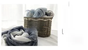Close-up of lightweight linen scarf with blue and white gradient stripes in basket