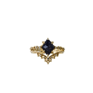 Dettaglio macro di anelli in oro K10 con pietra blu e design a pizzo a corona elegante
