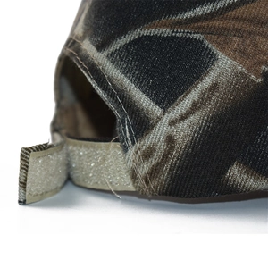Macro detail of camouflage baseball cap showing adjustable velcro strap and fabric texture