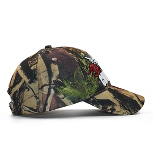 Detail view of 3D skull embroidery on camouflage baseball cap with tree leaf pattern