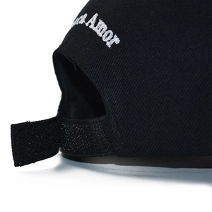Detail of adjustable velcro strap and Amor embroidery on black cotton baseball cap