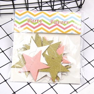 Close-up of gold, pink, and white glitter star garlands in clear party favors packaging